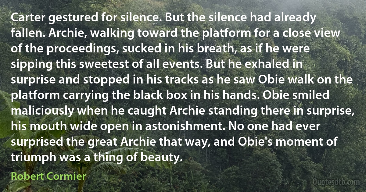 Carter gestured for silence. But the silence had already fallen. Archie, walking toward the platform for a close view of the proceedings, sucked in his breath, as if he were sipping this sweetest of all events. But he exhaled in surprise and stopped in his tracks as he saw Obie walk on the platform carrying the black box in his hands. Obie smiled maliciously when he caught Archie standing there in surprise, his mouth wide open in astonishment. No one had ever surprised the great Archie that way, and Obie's moment of triumph was a thing of beauty. (Robert Cormier)